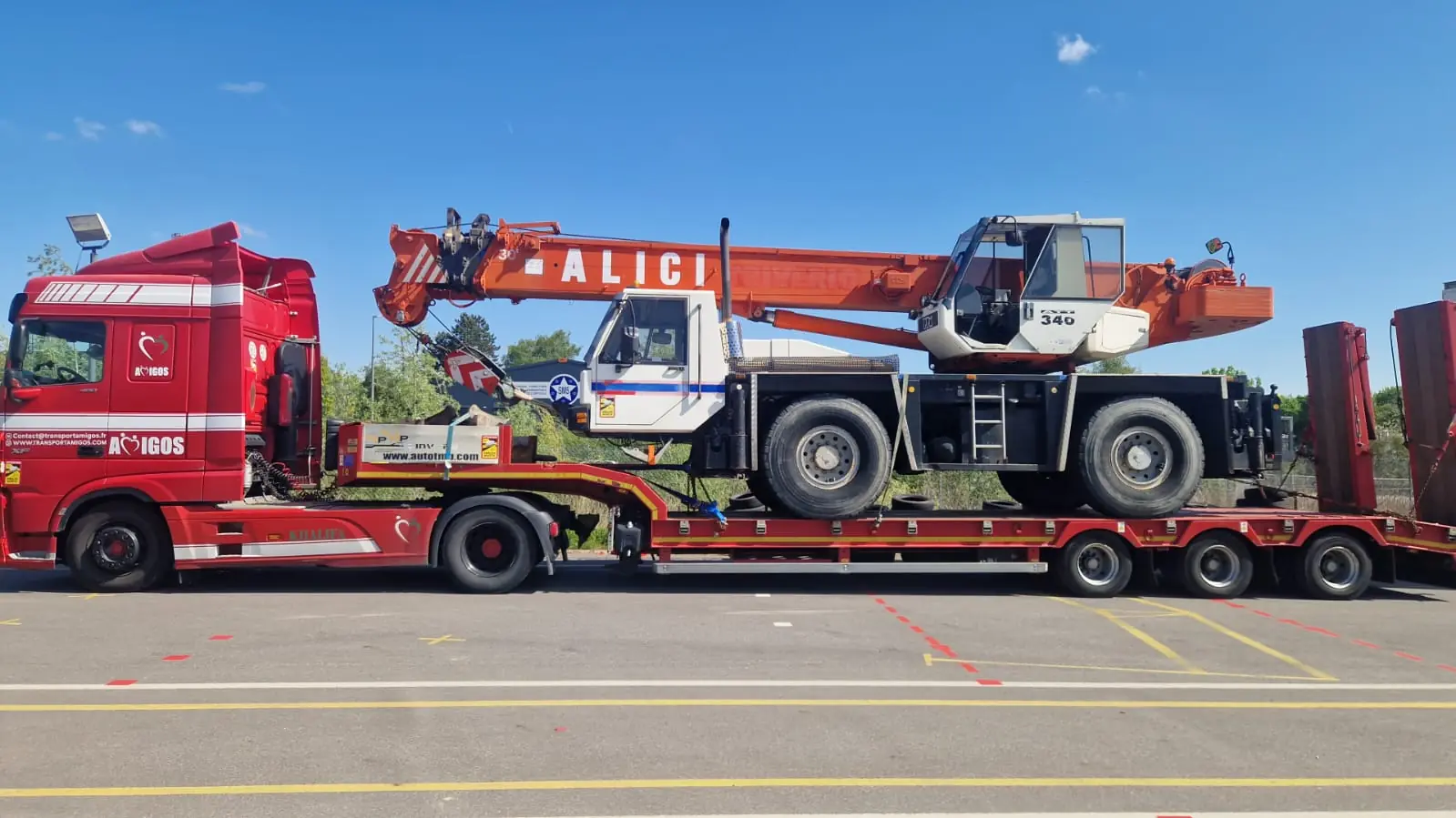 Camion Amigos Mobility transportant une grue mobile sur porte-engins